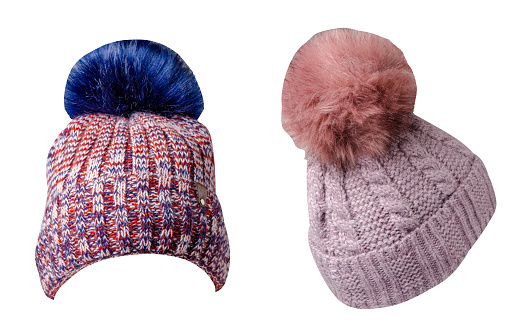 two  knitted red white blue and pink hats isolated on white background.hat with blue pompon .