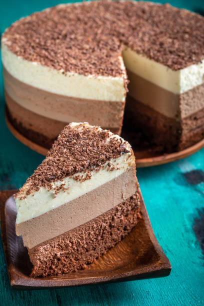 istock Triple chocolate mousse cake. Cream cake on aqua background 1409840038