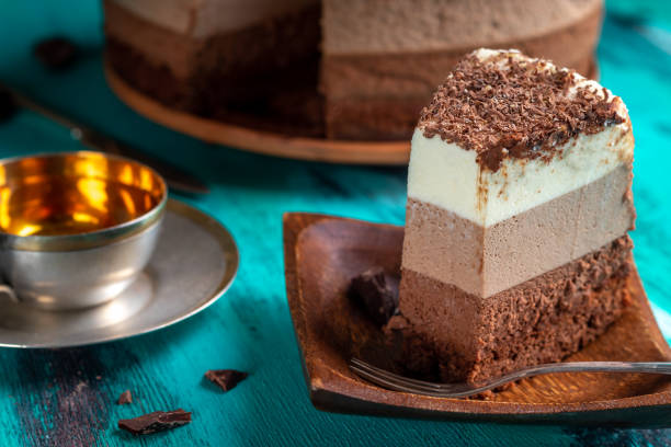 istock Triple chocolate mousse cake. Cream cake on aqua background 1409840065