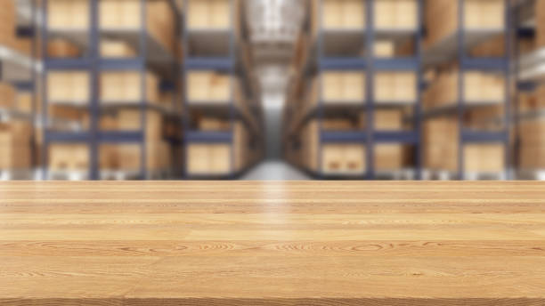 istock Focus on Wooden Table Top with a Blurred Warehouse Full of Boxes 1409840753