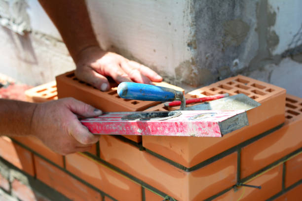 istock Bricklayer is checking with a spirit level if the corner of a brick wall 1409843532