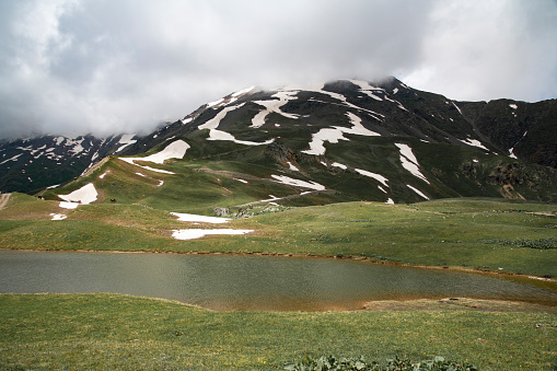 Beautiful mountains, foggy landscape. Small alpine lake and green meadows in the high mountains. Georgia Svaneti.