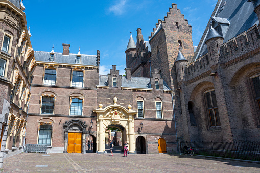 Binnenhof (Dutch Parliament), The Hague (Den Haag), The Netherlands. Visible are Historic buildings, art museum Mauritshuis along the pond Hofvijver, fountain and beautiful cloudscape over the reflection in the water.