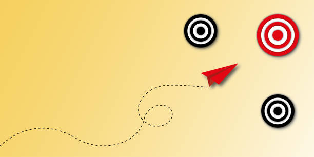 istock Red paper plane hitting in the red target centre on yellow background as metaphor for business target or goal success. 1409845256