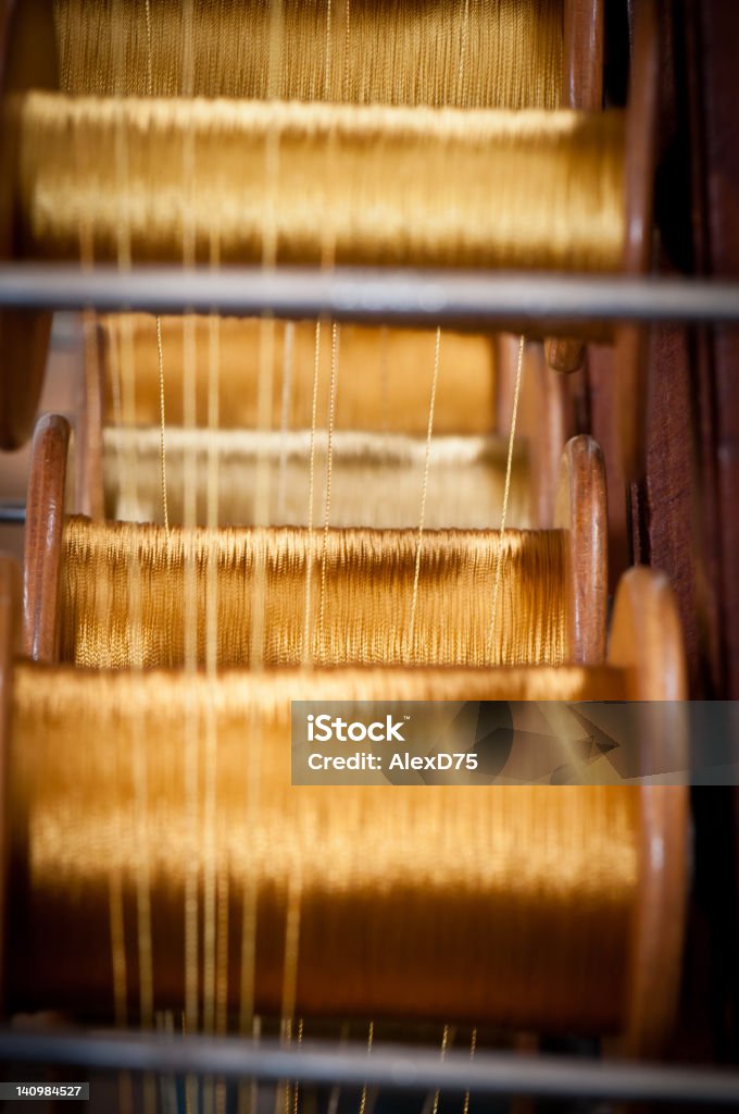 Gold spools in a textile factory Gold spools used to made highend fashion fabric Gold Colored Stock Photo