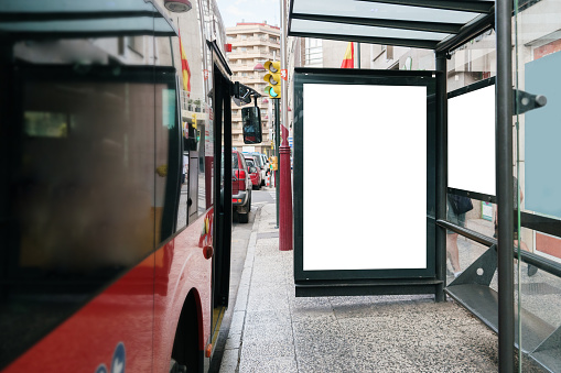 A bus stop in a city street with a blank placard for advertisements