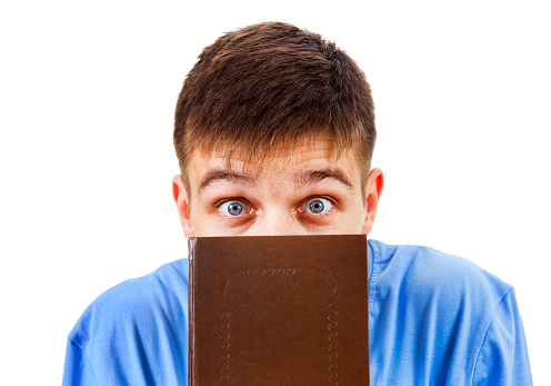 Surprised Young Man behind a Book on the White Background closeup