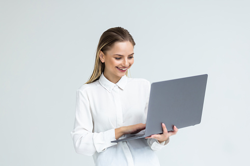 Portrait of a businesswoman working on laptop computer isolated over white background