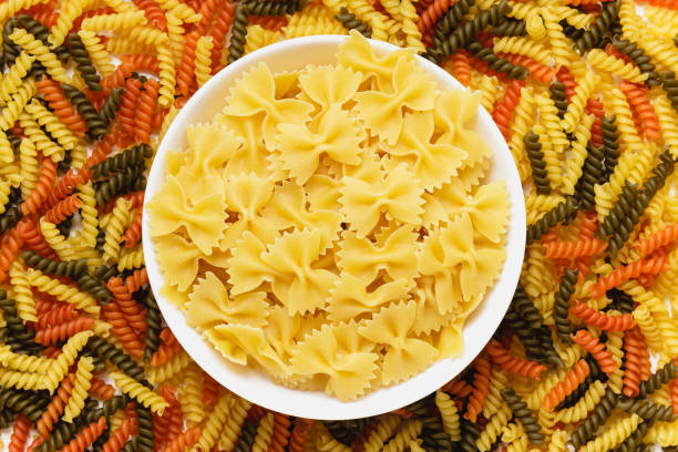 istock Raw pasta torti and farfalle in white bowl. 1409847659