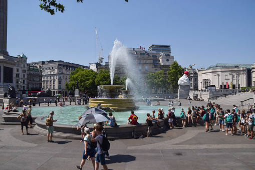 London, UK - July 19 2022: People cool down in the fountains at Trafalgar Square on the hottest day ever in the UK.