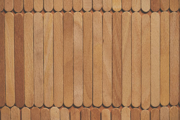 Wooden popsicle sticks, placed in a rows on top of a beige background Wooden popsicle sticks, placed in a rows on top of a beige background. Flat lay popsicle stick stock pictures, royalty-free photos & images
