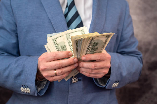 istock Business man on day holdings with dollar banknotes in his hands. 1409852484