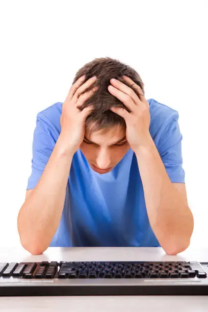 Sad Young Man with a Computer Keyboard on the White Background