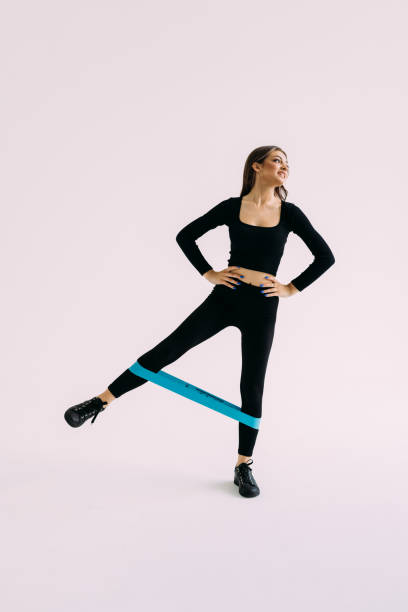 istock Sportswoman doing workout with resistance band, stretching elastic rope, exercising for fit and strong body in gym on white background 1409852529