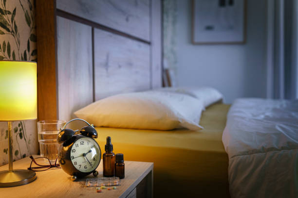 istock Alarm clock and sleeping pills on night table. Insomnia and sleep disorder concept 1409864766