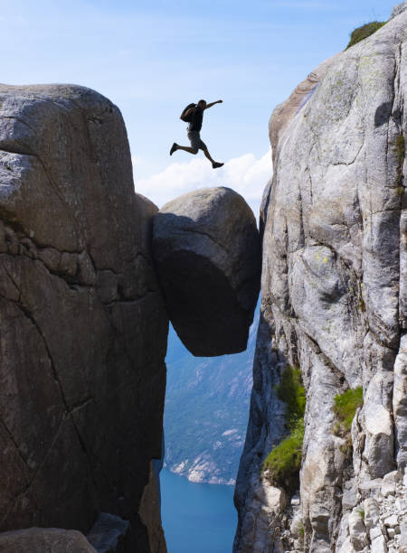 istock Man jumping between mountains, business concept idea 1409865115