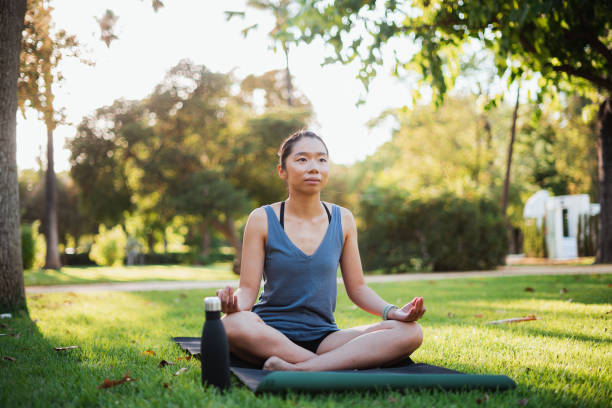 istock Young woman meditating outdoors 1409866028