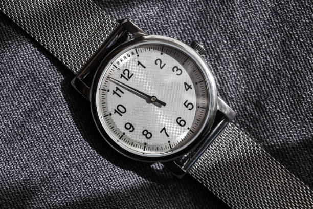Close-up view of a sleek black wristwatch with minimalist design, perfect for fashion, branding, or time management themes, elegantly displayed on a modern dark background with dramatic lighting.