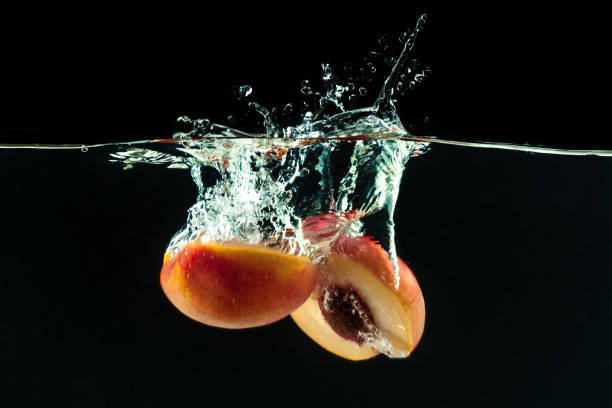 Peach dropped into water with bubbles