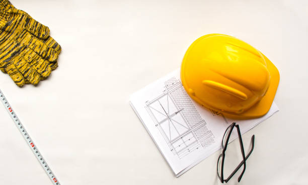 istock Construction drawings, hard hat, tape measure and gloves on a white background 1409866724