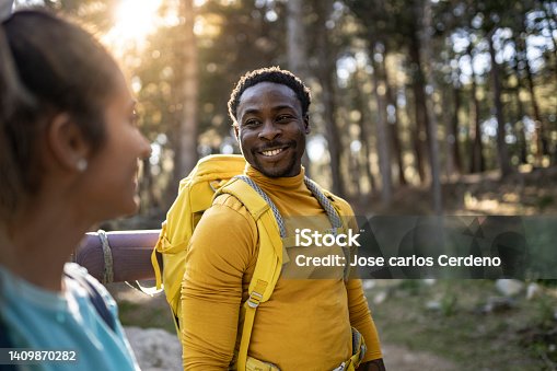istock young adventurous mountaineers in the forest at sunset - focus on african man - 1409870282