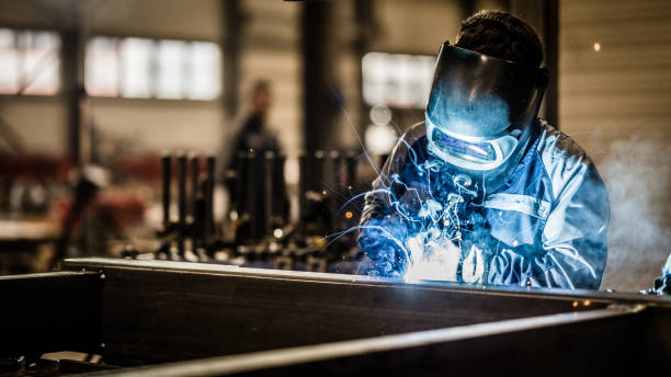 employee working in welding workshop - kaynak torcu stok fotoğraflar ve resimler