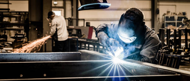 istock Workers welding and grinding steel products in workshop 1409873084