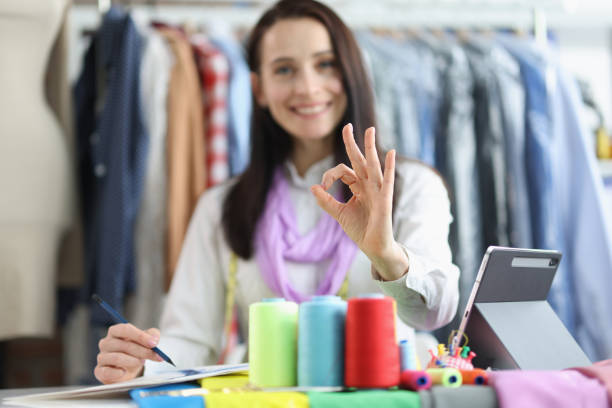 istock Dressmaker woman holding ok gesture while working in studio 1409873680