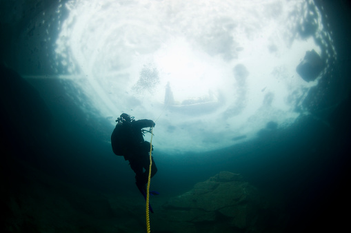 Winter ice diving underwater in a quarry in Canada
