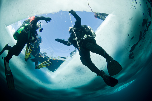 Winter ice diving underwater in a quarry in Canada