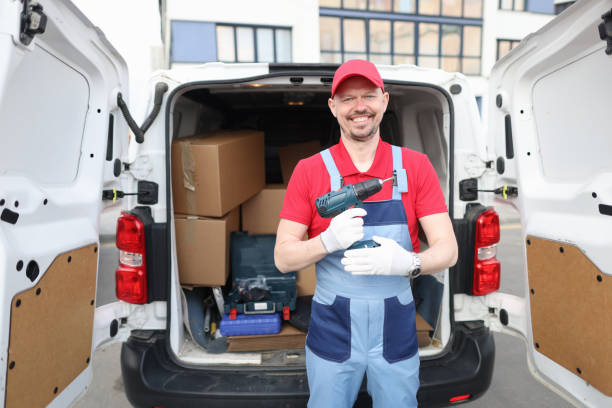 istock Smiling builder holding drill near car. Service repairman concept 1409874443