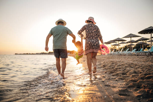 바다에서의 휴가, 모래 사장을 따라 걷는 조부모 - men footprint beach sunset 뉴스 사진 이미지