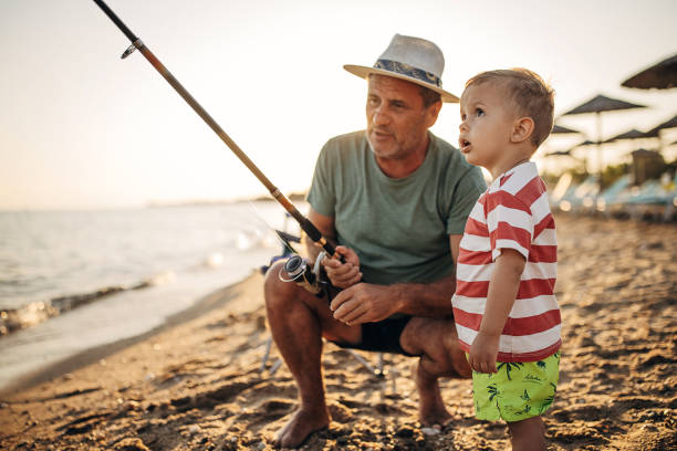 Old man takes his grandson to fishing in the morning