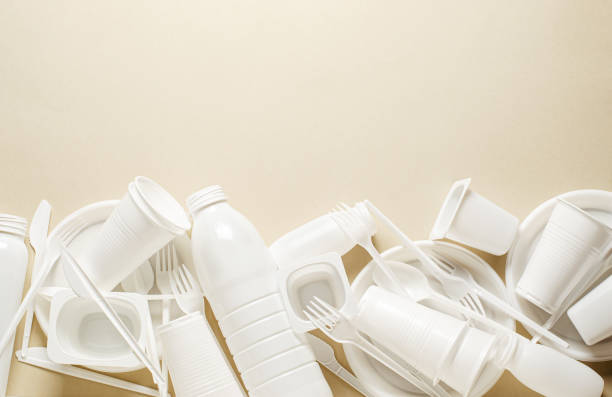 istock Disposable white plastic tableware on a beige background. The concept of nature pollution. Copy space. 1409877565