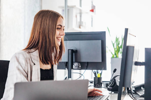 istock Happy Smiling Woman In Modern Office Reading E-Mails 1409877942
