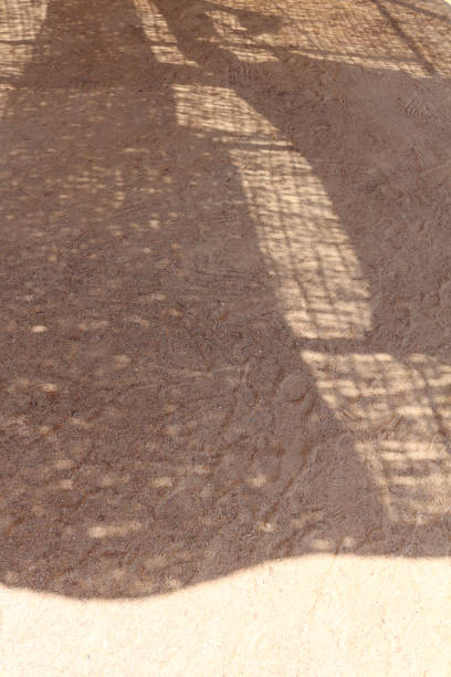 istock Sand texture with abstract geometric shadows. Shadows on the sand. Sandy beach background, summer concept. 1409878507