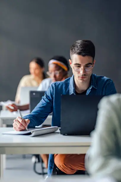 Photo of University Students Taking Notes While Sitting In The Classroom