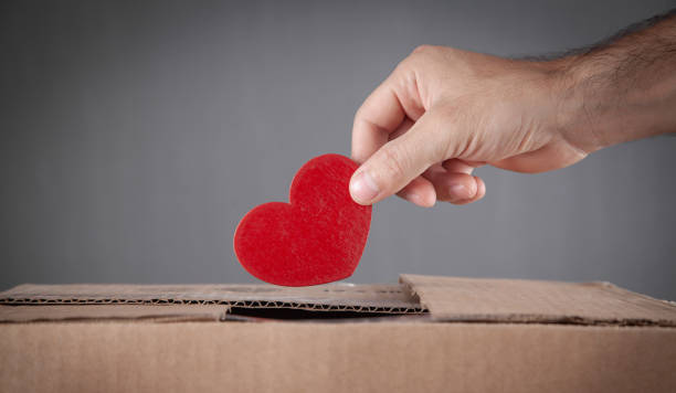 istock Male hand putting red heart in box. 1409879949