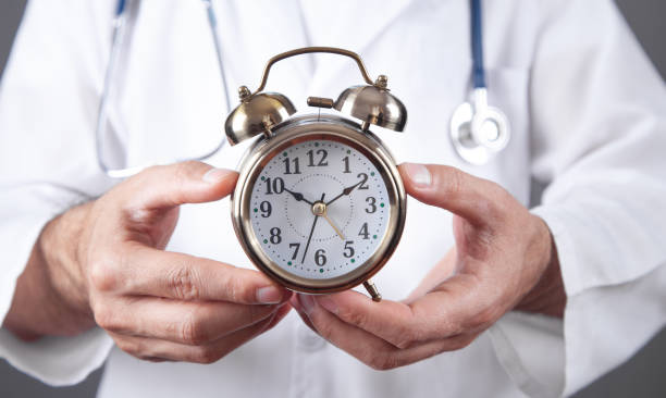istock Caucasian doctor holding alarm clock. 1409879958