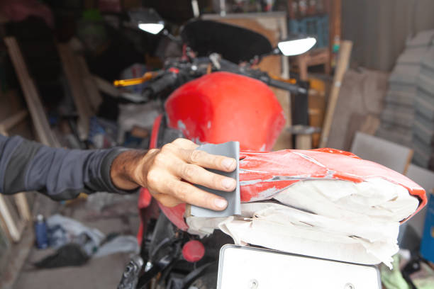 Preparation for painting a motorcycle. Hand in a sandpaper