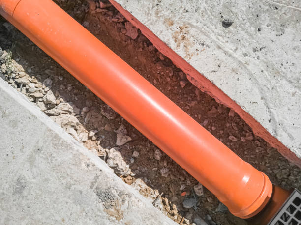 istock Laying an orange plastic drainage pipe. Top view. 1409880604