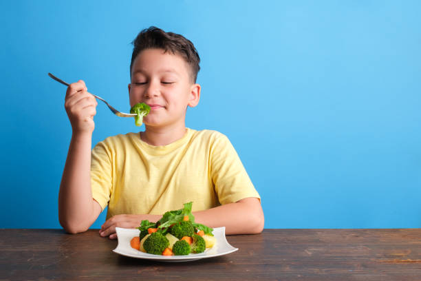 istock Child eating vegetables and happy 1409885457