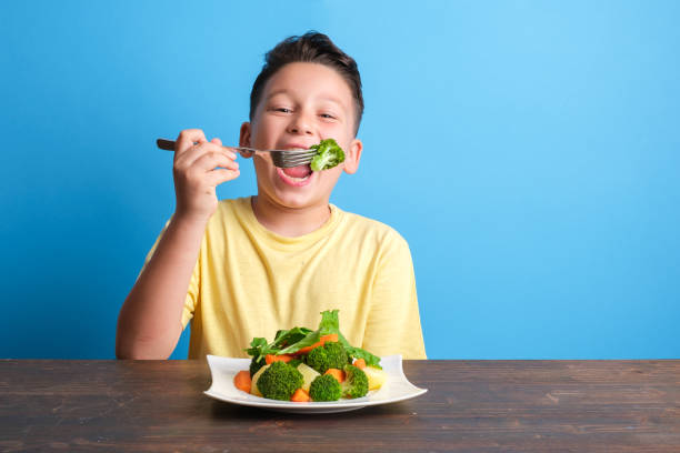 istock Child eating vegetables and happy 1409885542