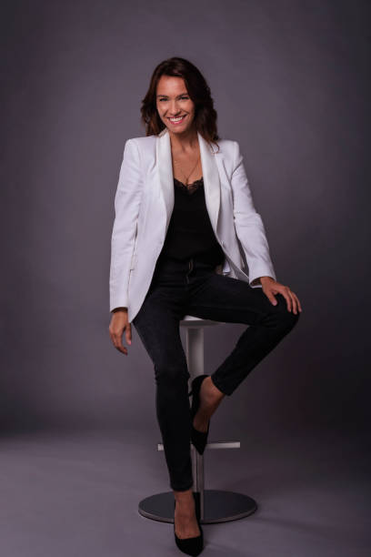istock Beautiful brown haired woman studio shot while sitting at isolated background 1409885543