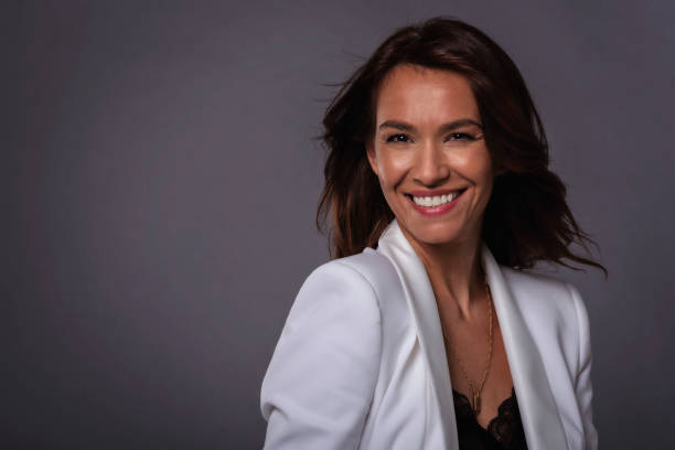 istock Beautiful brown haired woman studio shot while sitting at isolated background 1409885545