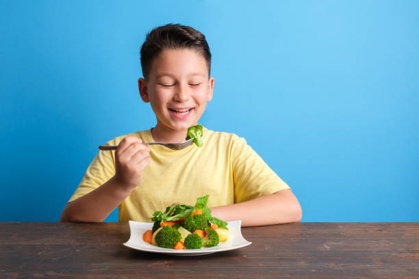 istock Child eating vegetables and happy 1409885593