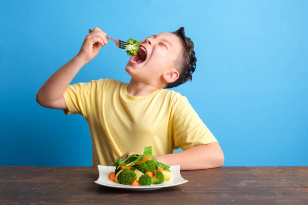 istock Child eating vegetables and happy 1409885691