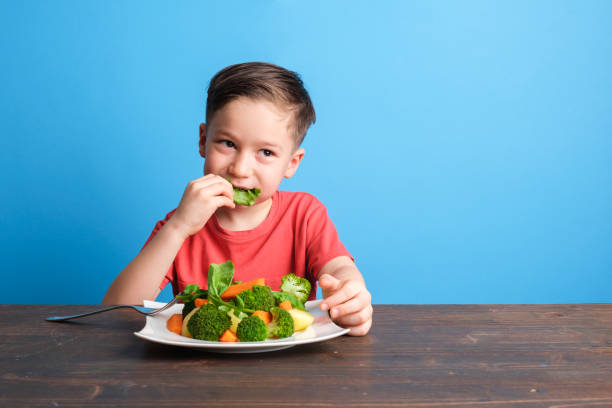 istock Child eating vegetables and happy 1409885692