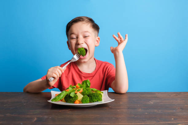 istock Child eating vegetables and happy 1409885977