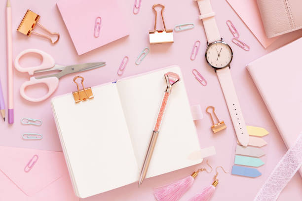 istock Opened notebook and Pink school girly accessories on pastel pink Top view, mockup 1409889656